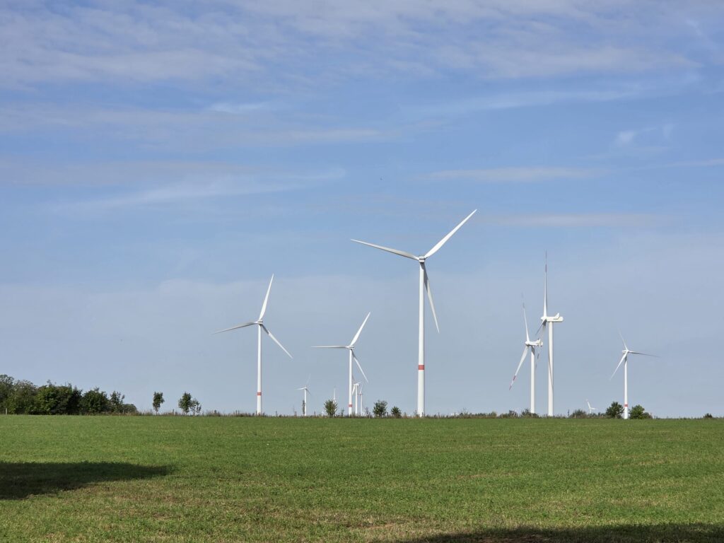 Windräder in einer monotonen, ebenen Agrarlandschaft